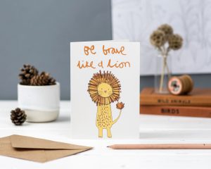 Hand illustrated be brave like a lion greeting card with illustrated cute lion on