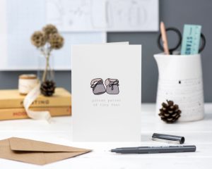 Hand illustrated winter baby shoes greeting card new baby with text pitter patter of tiny feet